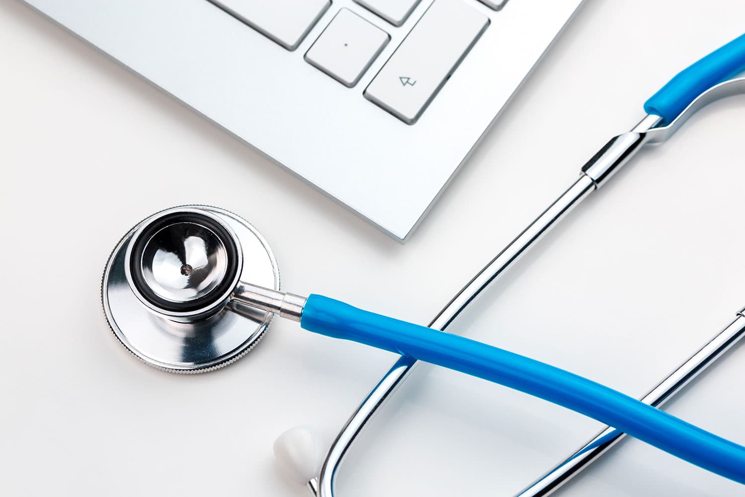 Stethoskop liegt neben Laptop